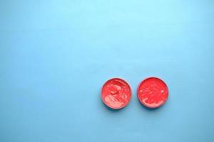 top view of used petroleum jelly in a container on blue background photo