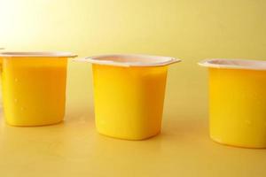 fresh yogurt in a yellow color plastic container photo