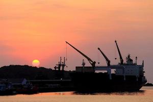 Cargo ship in the harbor at sunset photo