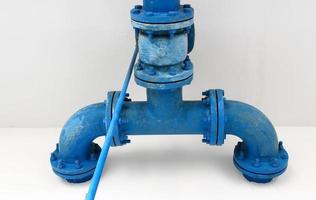 blue pipe line with blue valve on  wall photo