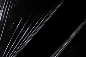 a black transparent plastic texture with hole for poster and cover art. realistic plastic wrap for overlay, copy space and photo effect. wrinkled plastic surface on black background