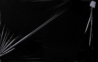 Black transparent plastic wrap texture overlay background. Realistic plastic for poster design and photo overlay effect. Wrinkled plastic surface pattern for graphic design sources and element.