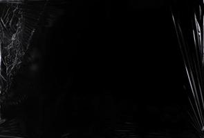 Black transparent plastic wrap texture overlay background. Realistic plastic for poster design and photo overlay effect. Wrinkled plastic surface pattern for graphic design sources and element.