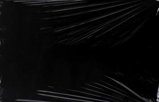 Black transparent plastic wrap texture overlay background. Realistic plastic for poster design and photo overlay effect. Wrinkled plastic surface pattern for graphic design sources and element.