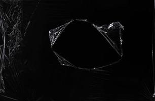 una textura de plástico transparente negra con un agujero para el afiche y la portada. envoltura de plástico realista para superposición, espacio de copia y efecto fotográfico. superficie de plástico arrugada sobre fondo negro foto