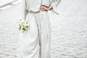 elements of a woman's casual suit with a bouquet of callas photo