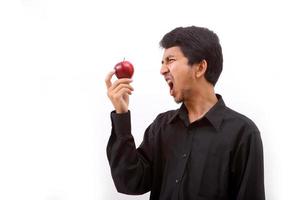 Young healthy man eating a red apple photo