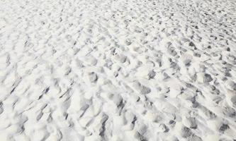 sand beach, wave and footsteps at sunset time photo