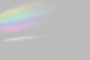 resumen de la superposición de luz de prisma de arco iris borrosa sobre fondo gris para maqueta y decoración foto
