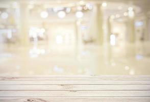 Empty wooden board table top on blur abstract of shopping mall background, for montage product or display, mock up for display of product photo