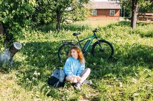 A young woman uses a modern electric bicycle for sports and outdoor recreation photo