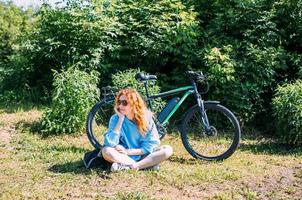 A young woman uses a modern electric bicycle for sports and outdoor recreation photo