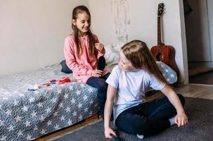 dos amigas colegialas juegan en casa, se peinan foto