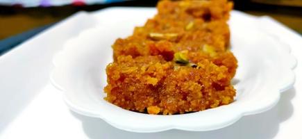 halwa de zanahoria casero, dulce indio tradicional, en plato blanco foto