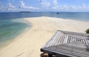 Wooden jetty on tropical beach on island photo