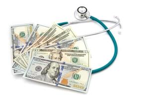 health care costs - Stethoscope on money background photo