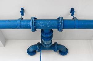 blue pipe line with blue valve on  wall photo