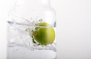 lemon   falling into glass of water photo