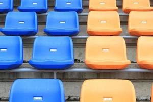 plástico, amarillo y azul, sillas nuevas en el estadio. foto