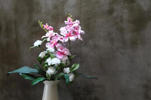 Bouquet of peonies in a vase against  wall. Interior photo