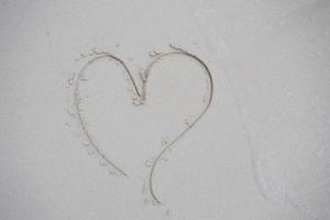 hearts drawn on the sand of a beach photo