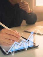 businessman working with statistics, looking at laptop and phone screens with graphs and diagrams, synchronizing electronic devices, checking financial report presentation, sitting at desk photo