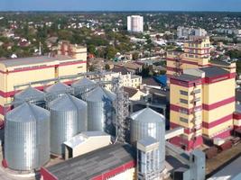 silo agrícola. almacenamiento y secado de granos, trigo, maíz, soja, contra el cielo azul con nubes. foto