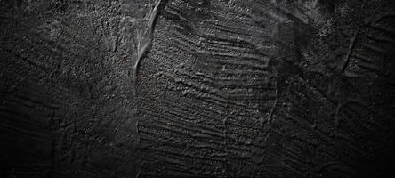 fondo de piedra negra oscura. textura de hormigón negro aterrador. fondo de pared de piedra. foto