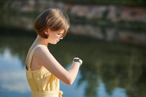 A teenage girl sets up a fitness tracker. Walking tour. photo