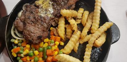 The best food in the world beef steak along with fried potatoes with delicious mushroom sauce and salad plated in beautiful black stripes plate photo