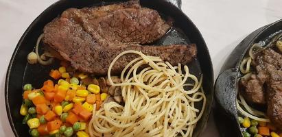 The best food in the world beef steak along with fried potatoes with delicious mushroom sauce and salad plated in beautiful black stripes plate photo