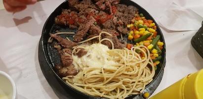 The best food in the world beef steak along with fried potatoes with delicious mushroom sauce and salad plated in beautiful black stripes plate photo