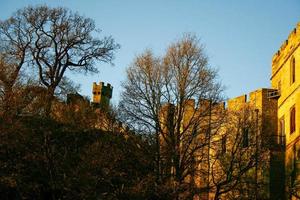 Ancient European medieval architectural building castle in golden autumn light with the blue sky background during autumn photo