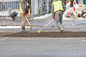 A construction team is patching up the pavement of the carriageway. photo