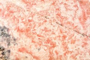 Coral marble surface. Beautiful color and texture with various wavy inclusions. Polished surface. photo