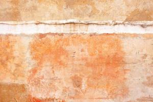 textura de una vieja pared de arcilla con grietas y rasguños y una costura entre pisos. foto