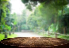 Selected focus empty brown wooden table and green garden or forest blur background with bokeh image. for your photomontage or product display. photo