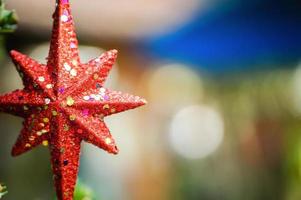 feliz navidad y felices fiestas estrella roja, fondo borroso. foto