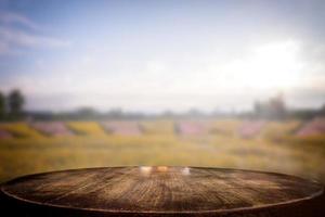 foco seleccionado mesa de madera vacía y vista de muchas flores fondo borroso con imagen bokeh. para su fotomontaje o exposición de productos. foto