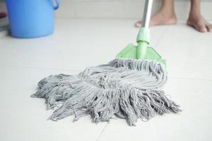 cleaning tiles floor with mop photo