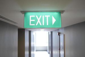 Fire exit sign in the middle of the the corridor in building photo