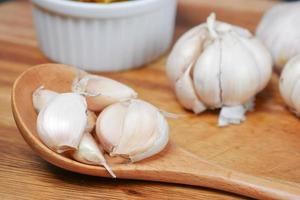 close up pf garlic on a wooden spoon on table photo