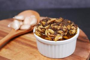 Homemade Garlic Pickle in a glass jar on table , photo