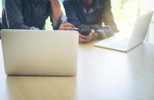 proceso de trabajo en equipo de negocios, manos de hombres de negocios apuntando a teléfonos inteligentes y documentos durante la explicación de los nuevos datos del proyecto del plan en la reunión. foto