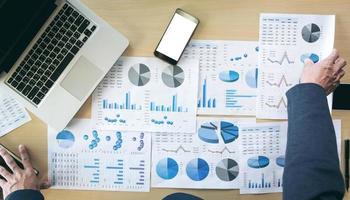 businessman hands working with computer and smart phone with business graph on desk as concept. photo