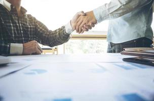 Two businessmen shaking hands during a meeting in the office, success, dealing photo