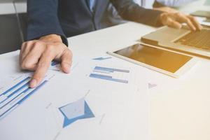 Image of business, business team working with laptop, tablet and financial document data graph on table in office. photo