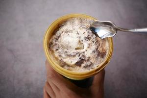 hombres jóvenes comiendo helado con sabor a vainilla en un recipiente foto