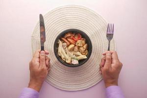 joven con tenedor esperando en un plato lleno de vegetales foto