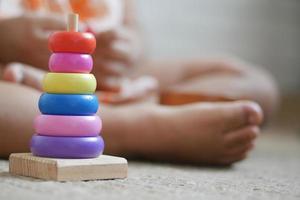 niño jugando con un bebé juguetes en la cama, concepto de desarrollo infantil. foto